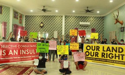 Community members hold signs protesting lack of consultation in timber concessions